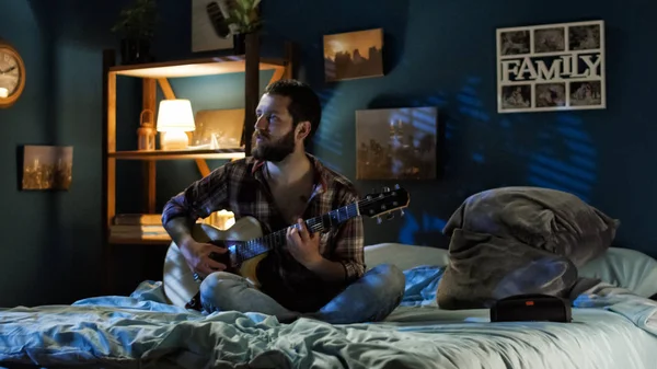 Pareja juguetona cantando con guitarra en la cama — Foto de Stock