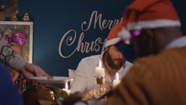 Diverse Freunde beim gemeinsamen Essen zu Weihnachten — Stockvideo