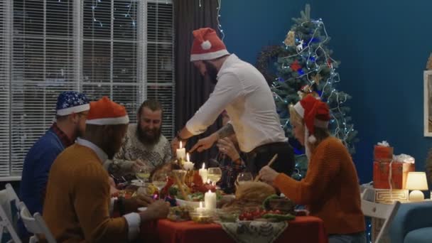 Lachende Freunde beim Truthahnbraten beim Weihnachtsessen — Stockvideo