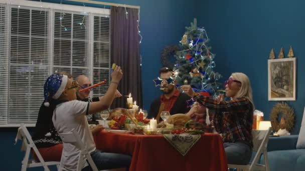 Verspielte Familie feiert Weihnachten beim Essen — Stockvideo