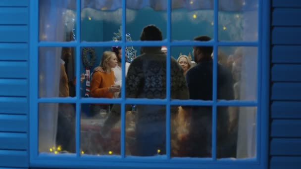 Podekscytowany znajomych patrząc w okno podczas świąt Bożego Narodzenia — Wideo stockowe