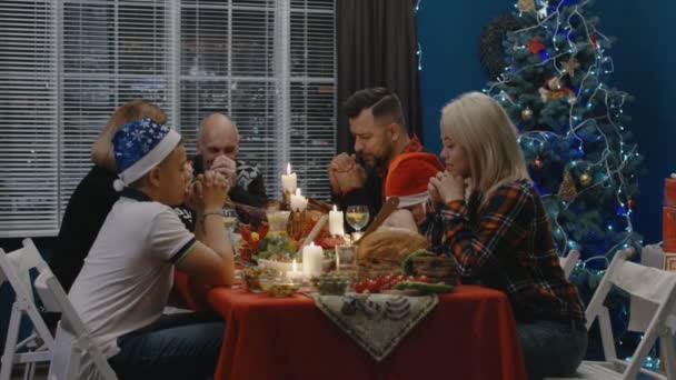 Familia ofreciendo oraciones mientras celebra la Navidad — Vídeos de Stock