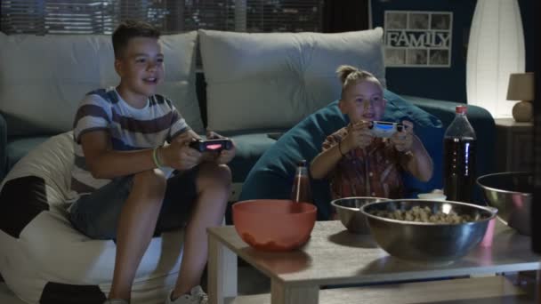 Genç çocuklar video oyunu birlikte kanepede oynama — Stok video