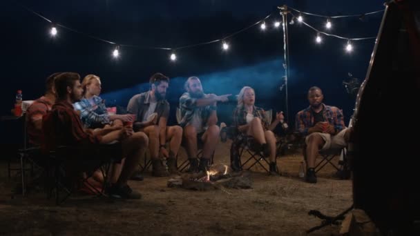 Young people watching movies near campfire — Stock Video