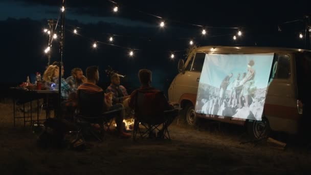 Amigos assistindo filme no acampamento — Vídeo de Stock