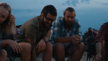 Alacakaranlıkta kamp ateşi üzerinde Sosis kızartma arkadaşlar