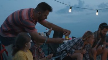 Kamp ateşi birlikte seyahat üzerinde kızartma sosis insanlar