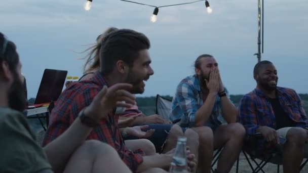 Смеющиеся разные друзья, играющие в шарады в лагере — стоковое видео