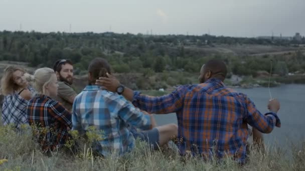 Pessoas diversas descansando na natureza e conversando — Vídeo de Stock