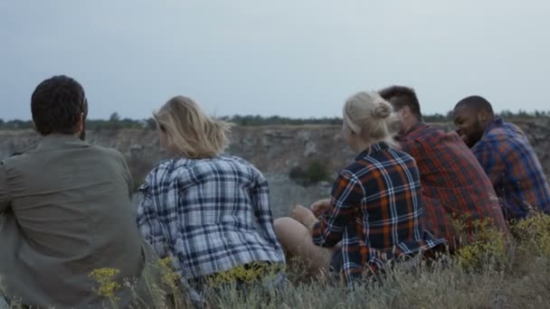 Друзья отдыхают на скале и веселятся — стоковое видео