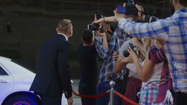 Kırmızı halı üzerinde fotoğrafçılar için poz sporcu avcı — Stok video