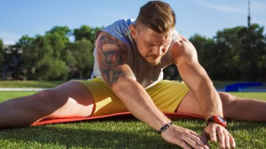 Mat yeşil alan üzerinde esneme sporcu