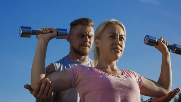 Hombre entrenando mujer en la luz del sol — Foto de Stock