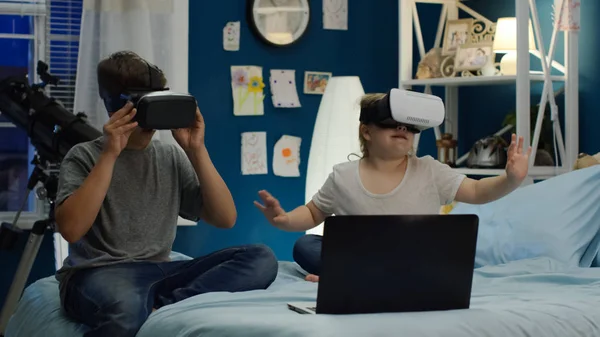 Niños jugando videojuego en gafas VR en la cama — Foto de Stock