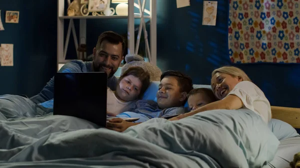 Inhoud familie kijken naar grappige film op laptop — Stockfoto