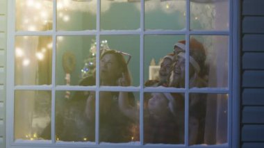 Mutlu aile pencereden havai fişek izlerken