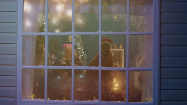 Podekscytowany znajomych patrząc w okno podczas świąt Bożego Narodzenia — Wideo stockowe