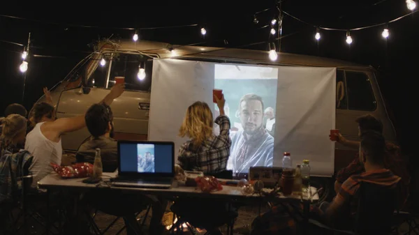 Des amis regardent un film à l'écran au camping — Photo