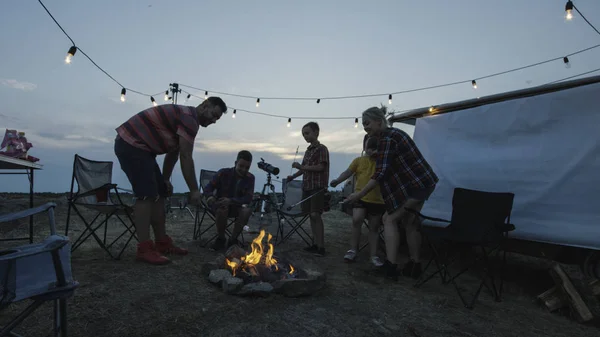 Skrattande familj stekning marshmellow på brasa — Stockfoto