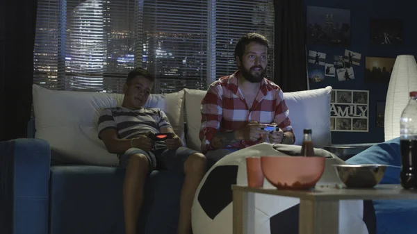 Homem e menino jogando videogame juntos — Fotografia de Stock