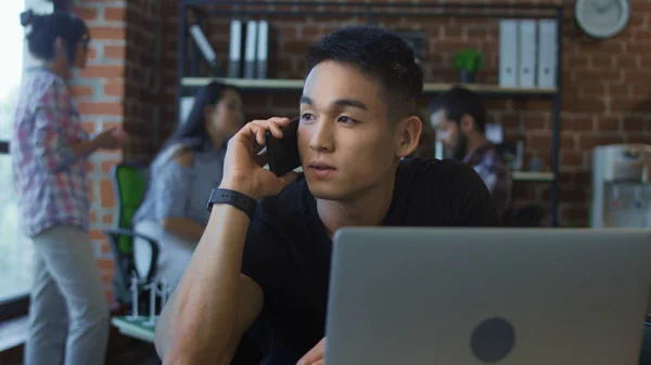 Uomo che parla al telefono sul posto di lavoro — Foto Stock