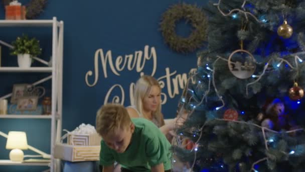 Pojke dekorera julgran hemma — Stockvideo
