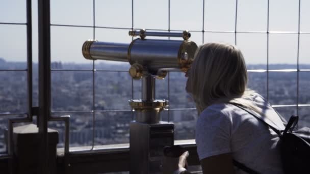 Mulher observando cidade com moeda binocular — Vídeo de Stock