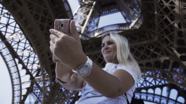 Szczęśliwa kobieta biorąc selfie pod wieżę Eiffla — Wideo stockowe