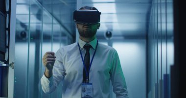 Veri merkezinde VR gözlük ve dizüstü bilgisayar kullanan adam