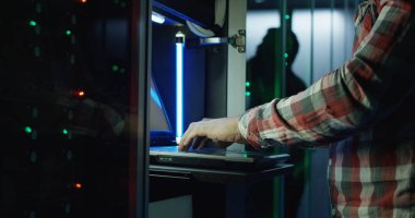 Sunucu odası veri merkezinin laptop ayakta üzerinde kareli gömlekli adam kırpma yan görünüm