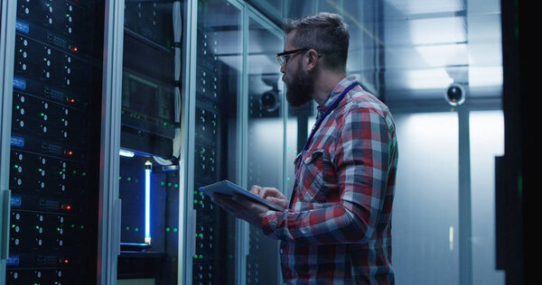 Bearded IT specialist setting servers in data center
