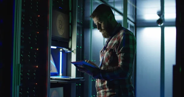 Man using laptop on mining farm in data center