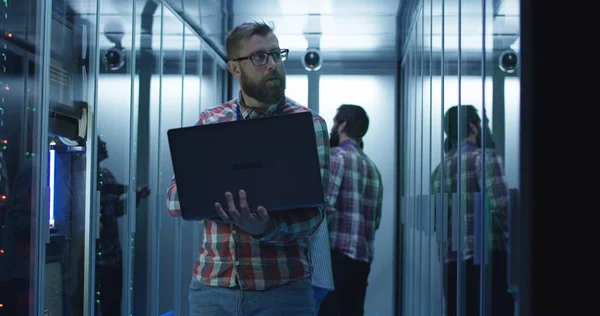 Ingeniero de TI barbudo usando computadora portátil en la sala de servidores — Foto de Stock