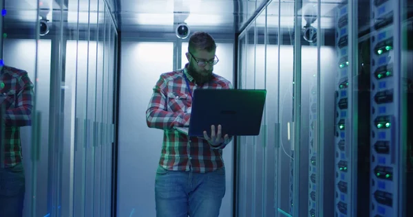 Ingeniero de TI barbudo usando computadora portátil en la sala de servidores — Foto de Stock