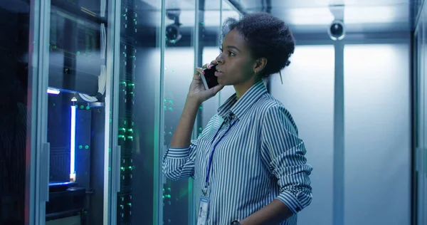 Mujer negra hablando por teléfono en la sala de servidores — Foto de Stock