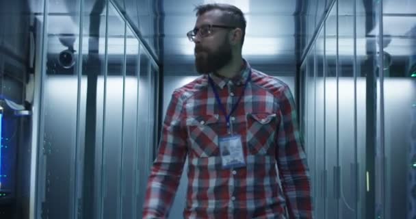 Бородатый ИТ-специалист устанавливает серверы в дата-центре — стоковое видео