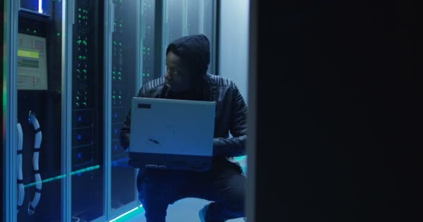 Crouched hacker i et datacenter – Stock-video