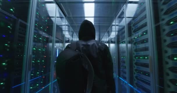 Hacker dengan ransel berjalan melalui baris server rak — Stok Video