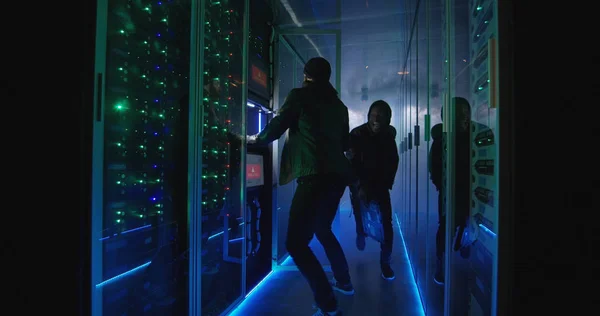 Dois hackers terminando de atacar e escapar de um data center smokey — Fotografia de Stock