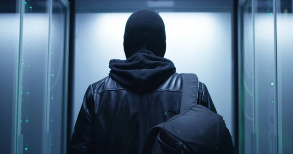 Hacker mit Rucksack läuft durch Reihen von Rack-Servern — Stockfoto