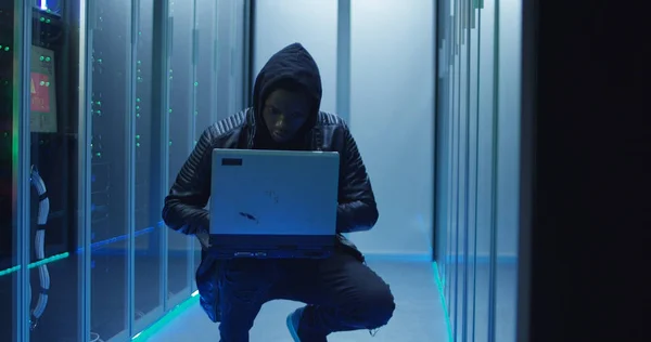 Hacker agachado en un centro de datos — Foto de Stock