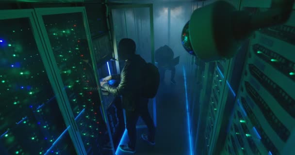 Två hackare i mask och hoodie på bärbara datorer — Stockvideo