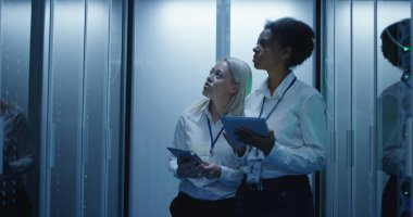 İki kadın bir veri merkezinde sunucu rafları satırlarının ile çalışıyoruz