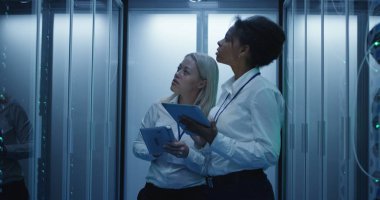 İki kadın bir veri merkezinde sunucu rafları satırlarının ile çalışıyoruz