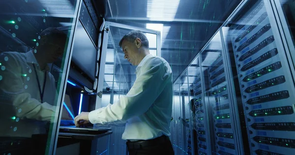 Técnico trabaja en un ordenador portátil en un centro de datos — Foto de Stock