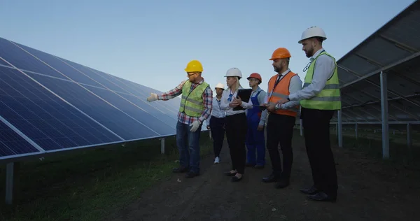 Trabajadores eléctricos caminando en una granja solar —  Fotos de Stock