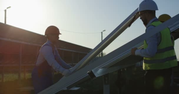 Drie werknemers installeren een zonnepaneel — Stockvideo