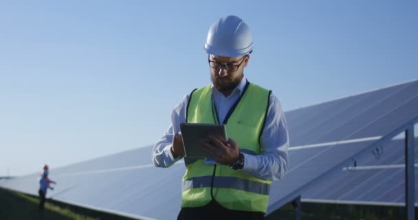 Elektrische arbeider te typen op zijn tablet buiten — Stockvideo