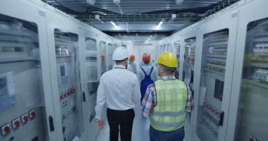 Geniş yürüyüş ve bir elektrik istasyonu kontrol odasında belgeleri gözden geçirme elektrik işçilerin arkadan çekim