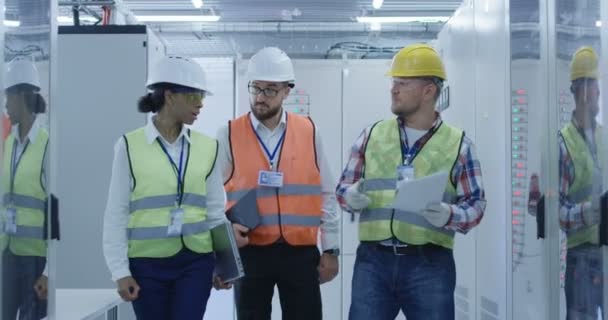 Різноманітні інженери з паперами, що ходять в центрі управління — стокове відео